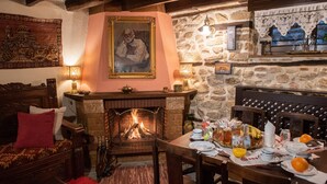 Una camera accogliente con camino, mobili in legno e un tavolo da pranzo apparecchiato per la colazione.
