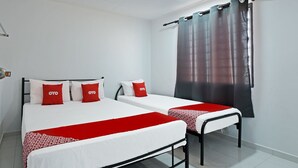 A hotel room with two beds, each with white bedding and red accents, a red and white patterned throw, and a window with a dark curtain. - OYO 90493 JL Homestay (Segamat)