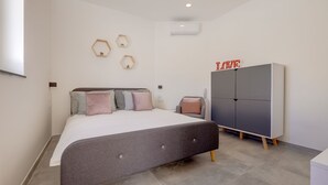 A bedroom with a bed, a wardrobe, and wall-mounted decor. - Perfect Location, Cosy 1BR Apartment (Sliema)
