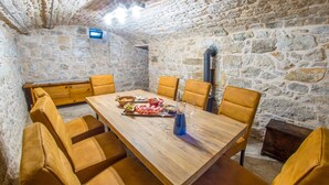 Una habitación con paredes de piedra, una mesa de madera y seis sillas.