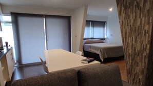 A modern hotel room with a dining area, a bed, and a view of the outside. - Modern, cosy and practical place (Montevideo)
