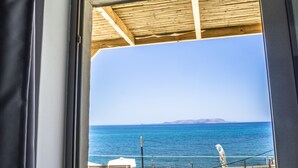 A view of the sea from a covered area with a wooden ceiling and a railing in the foreground. - Anfi Suites 3 - Sea View - Sunset Balcony - 3 Guests (Kato Gouves)