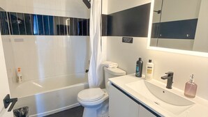 Un baño moderno con bañera, inodoro y lavamanos.