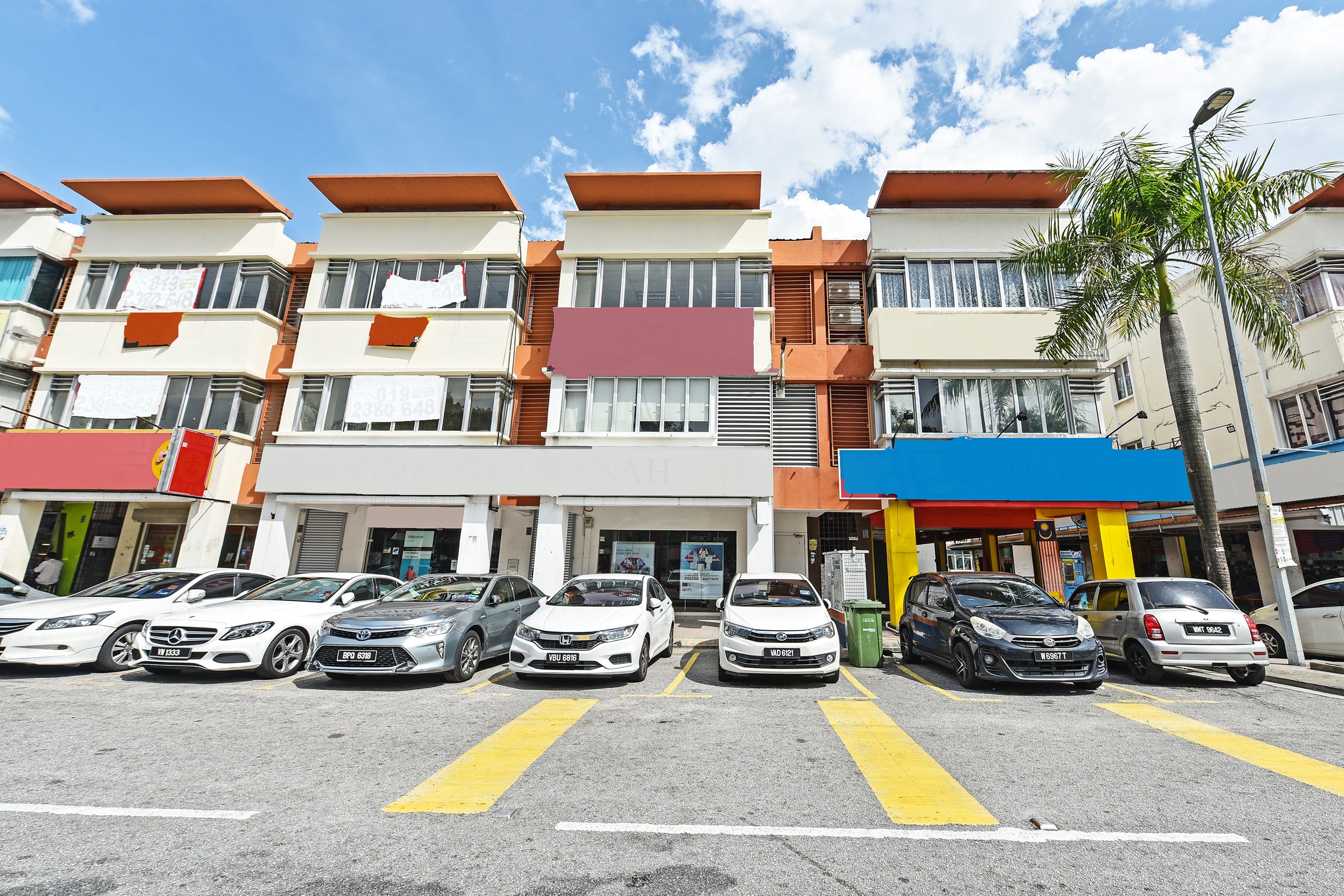 A multi-story residential building with a parking lot in front.