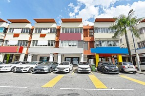 A multi-story residential building with a parking lot in front.