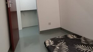 A room with a bed, a door, a ceiling fan, and a light switch. - Spot ON 90500 Sri Rampai Metro Hostel (Kuala Lumpur)
