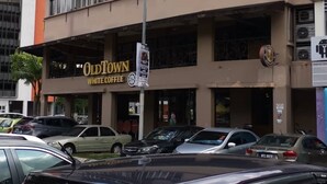 A building with a sign for "OldTown White Coffee". - Spot ON 90500 Sri Rampai Metro Hostel (Kuala Lumpur)