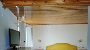A bedroom with a bed, a bedside table with breakfast, a TV on a stand, and a wardrobe. - Hotel La Maggioressa (Casamicciola Terme)