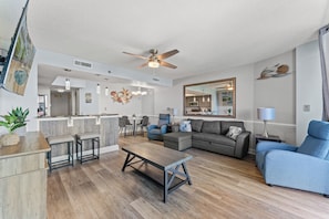 Un salon moderne comprenant un canapé, une table basse et un coin repas avec des chaises.