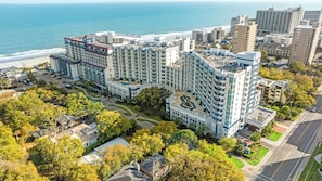Un hôtel de grande hauteur doté de nombreux balcons, d’une cour intérieure et offrant une vue sur la plage.