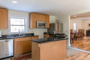 A modern kitchen with wooden cabinets, a built-in microwave, and a refrigerator.