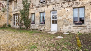 Un bâtiment en pierre avec un jardin à l’avant.