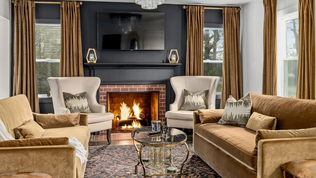 Una sala de estar acogedora con chimenea, dos sillones, un sofá y una mesita de centro.