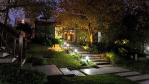 A well-lit outdoor pathway leading to a building with a glass entrance, surrounded by lush greenery and a wooden staircase. - O2 Hotel Valeria del Mar (Valeria del Mar)
