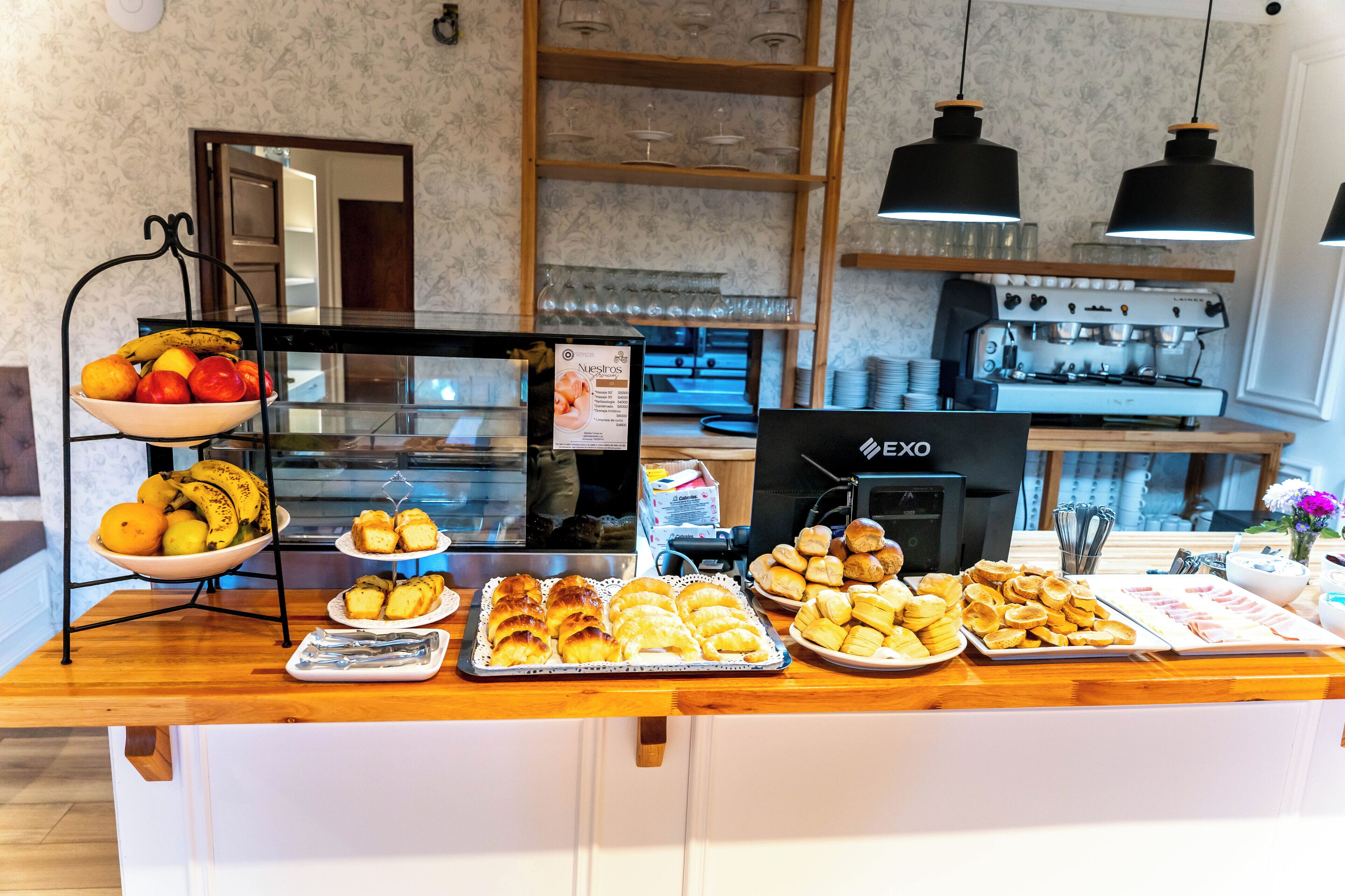 Un comptoir de buffet proposant divers plats, une machine à café et un miroir au mur.