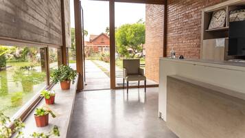 Una cocina moderna con un ventanal grande, una silla y plantas en macetas.