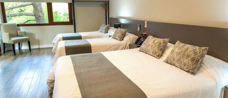 A hotel room with two beds, a desk, and a chair.