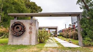 A concrete structure with a circular metal design and the letters "SPA" on it, leading to a modern building with large windows.