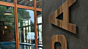 A modern interior with large glass windows, a wooden sign with letters, and a tiled floor. - O2 Hotel Valeria del Mar (Valeria del Mar)