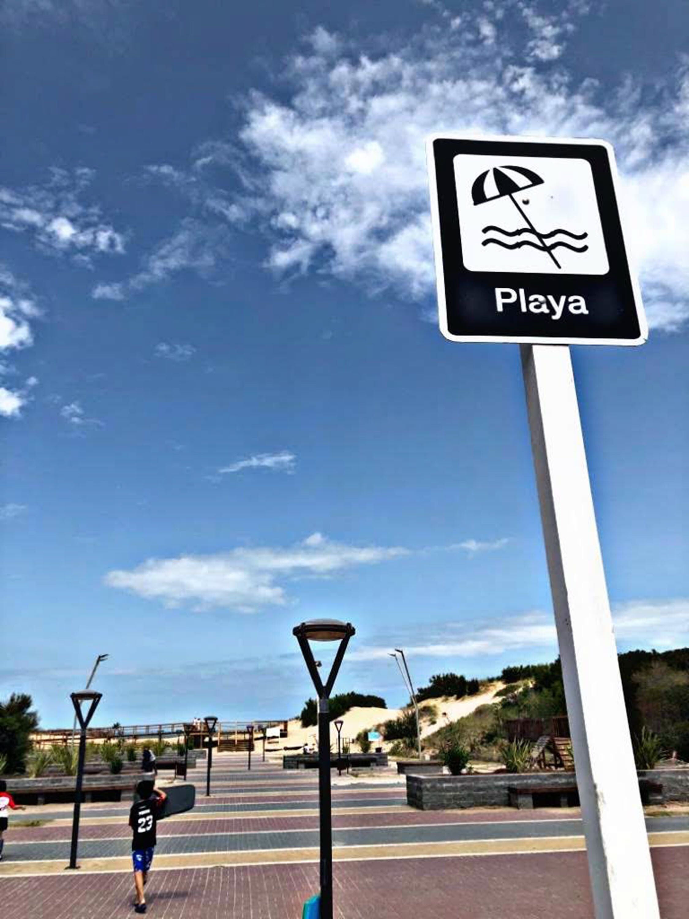 A beach sign with a wave icon and the word "Playa".
