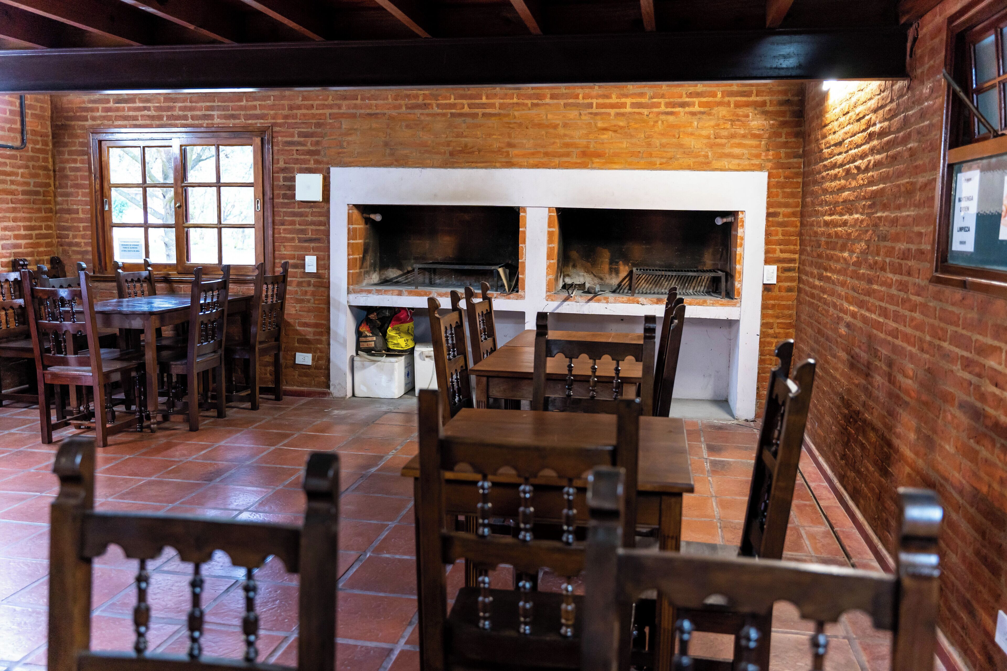 A restaurant with brick walls, a fireplace, and wooden furniture.