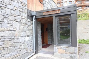 Un edificio in pietra con una porta di legno e un cartello sopra.