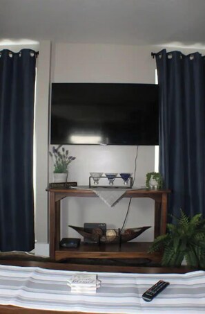 Relax in comfort with a flat-screen TV and console table, surrounded by decorative accents.