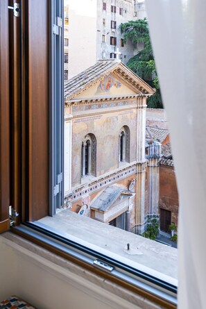 A view from a window of a building with classical architecture, including arched windows and decorative moldings. - Sentho Roma (Rome)