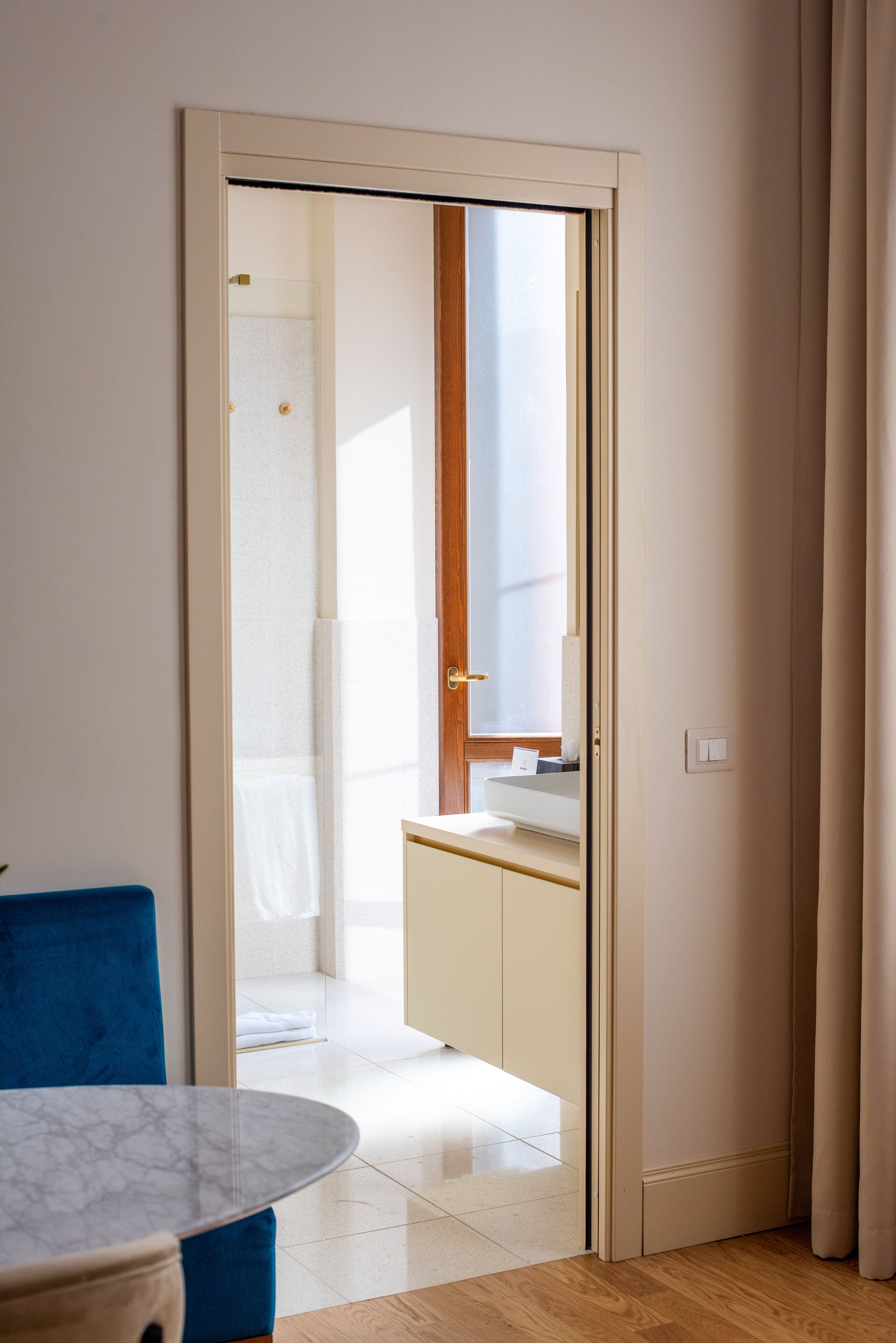Une chambre d’hôtel avec une porte donnant sur une salle de bain et une petite kitchenette.