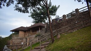 A stone staircase leading to a brick building with a wooden railing. - Rift Valley Game Lodge (Rubirizi)