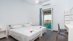 Una camera d'albergo moderna con due letti, una scrivania e una sedia.