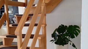 A wooden staircase with a potted plant beside it.