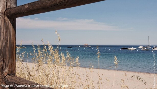 A beach with a wooden fence and dry grass in the foreground, a clear sky, and several boats in the water. - Villa Renajolo. 6 pers, 3 min plage en voiture (STE LUCIE DE PORTO VECCHIO)