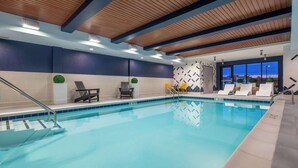 An indoor swimming pool with a wooden ceiling, tiled walls, and lounge chairs. - Home2 Suites by Hilton Fredericksburg South (Fredericksburg)