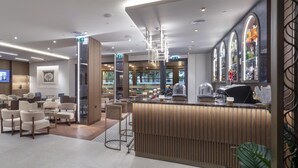 A modern hotel lobby with seating areas, a reception desk, and a bar. - Doubletree By Hilton Plovdiv Center (Plovdiv)