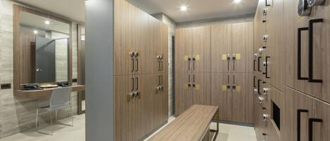 Un vestuario moderno con taquillas de madera, un banco y un espejo.