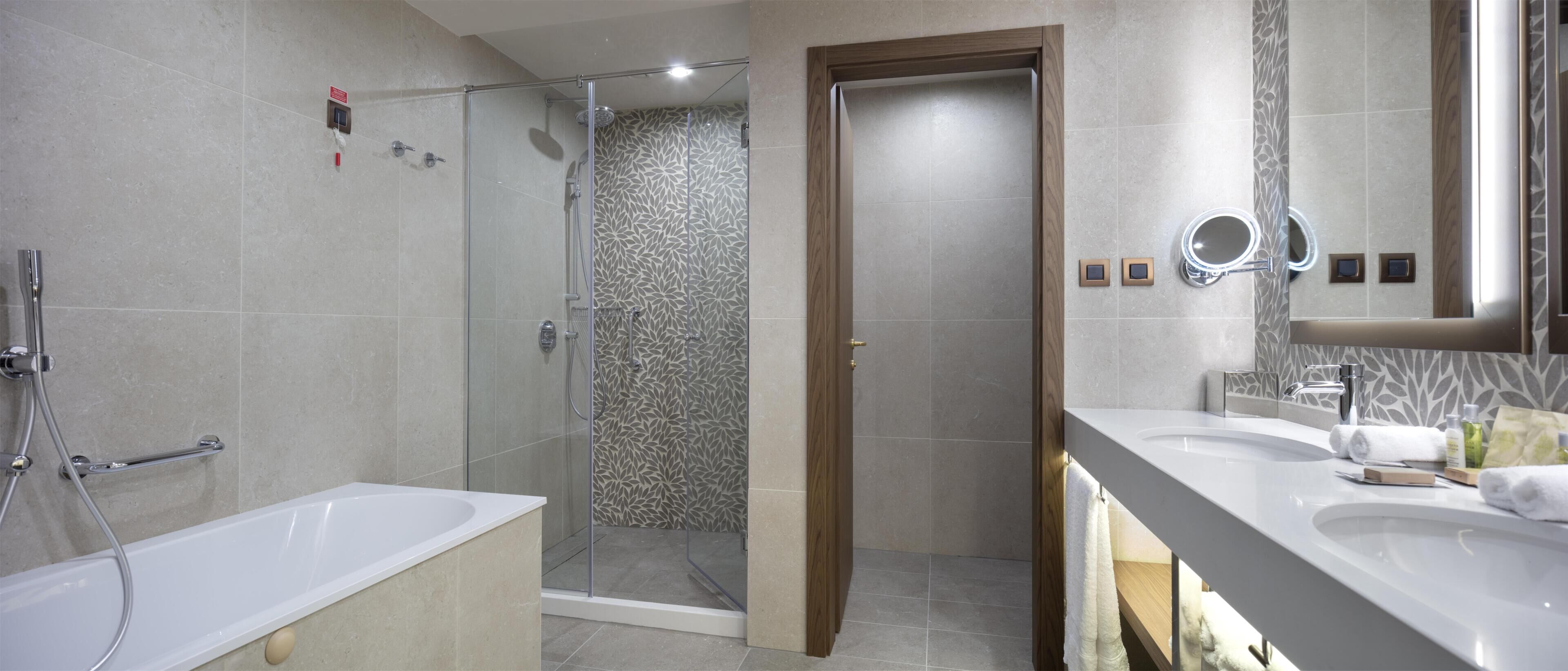 A modern bathroom with a bathtub, a shower enclosure, and a vanity with a mirror.