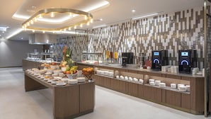 A modern buffet setup with a variety of food items, a fruit display, and a coffee station. - Doubletree By Hilton Plovdiv Center (Plovdiv)