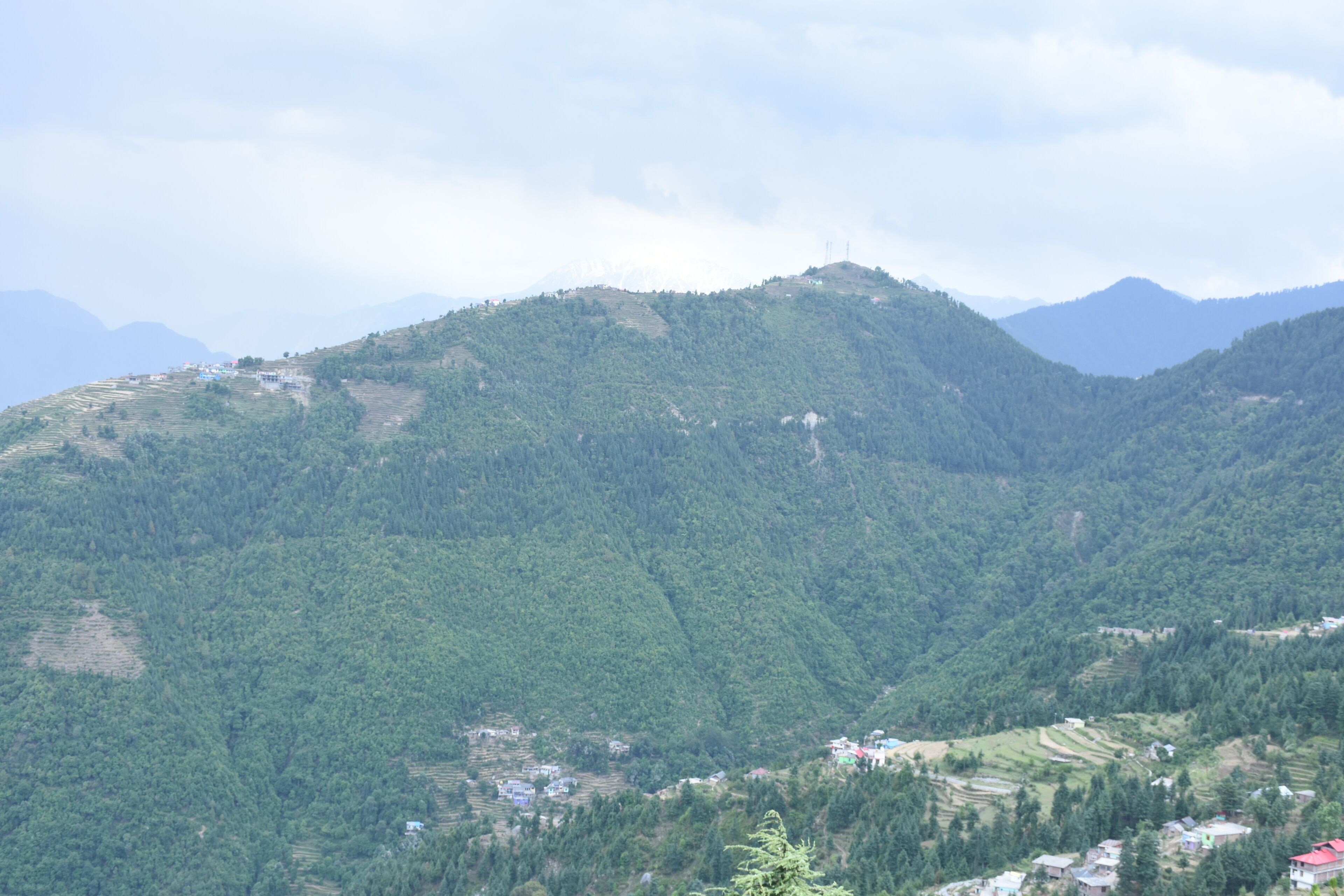 A mountainous landscape with terraced fields and scattered buildings.