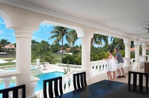 Relax by the pool surrounded by lush greenery and palm trees.