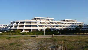 A modern building with a unique modular design, featuring multiple balconies and a flat roof.