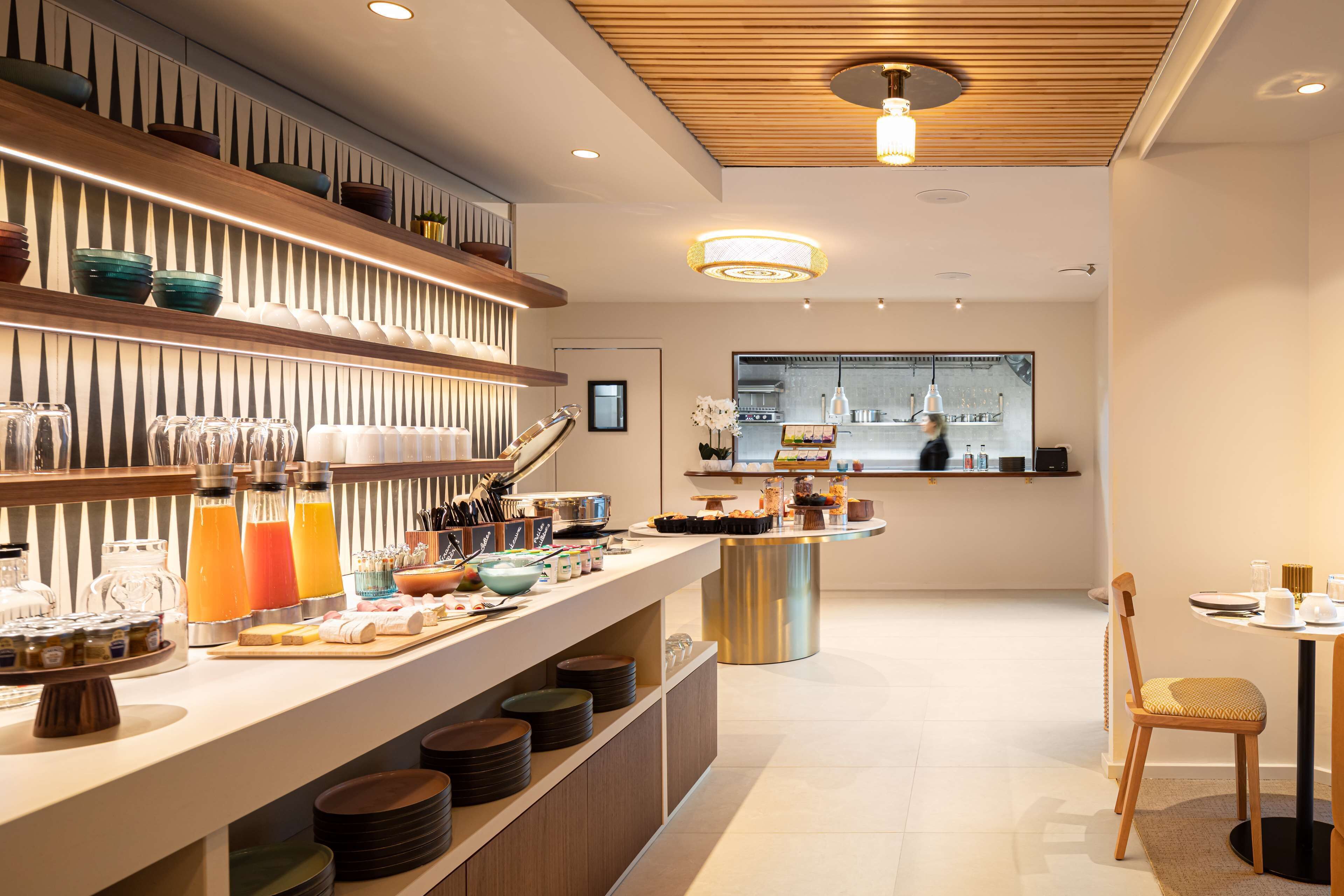 A modern kitchen with a buffet setup, including various food items and beverages.