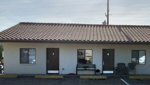 A building with a tiled roof and numbered doors from 7 to 10.