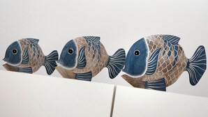 Three fish-shaped sculptures aligned in a row.