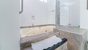 Un baño con bañera, ducha y ventana.