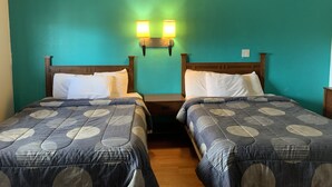 A room with two beds, teal walls, and two wall-mounted lights. - Fort Collins Inn (Fort Collins)