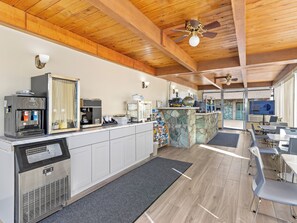 A modern kitchen with a coffee machine, a refrigerator, and a stone island.
