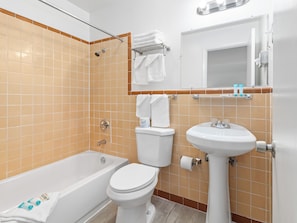 A bathroom with a bathtub, toilet, and sink.
