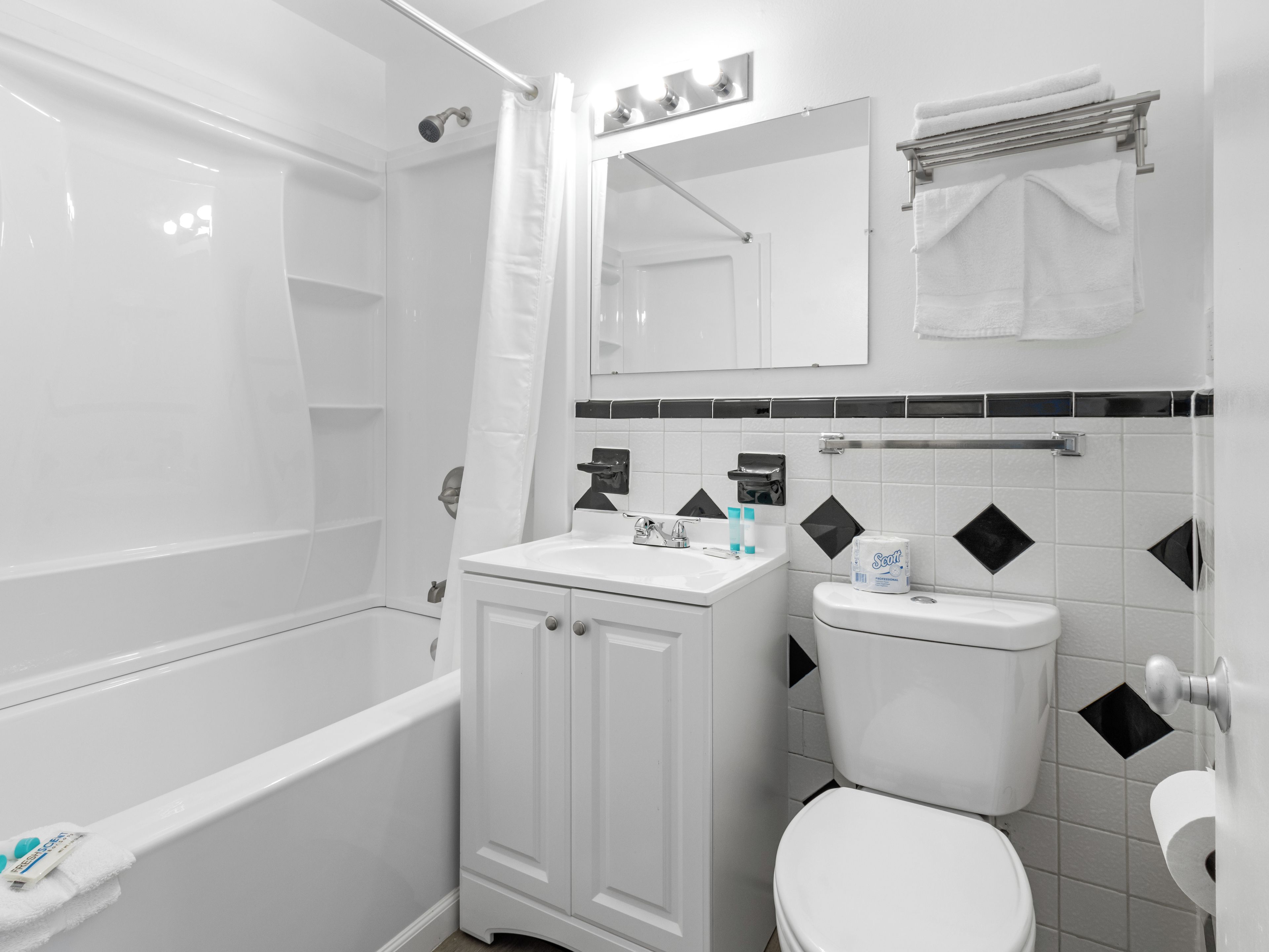 Un baño con bañera, inodoro, lavabo y espejo.
