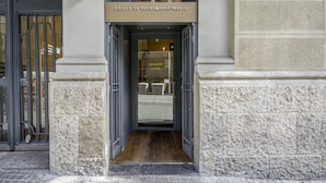 Entrada de un edificio con un letrero que dice "EXCLUS VE ROOMS&APARTMENTS".